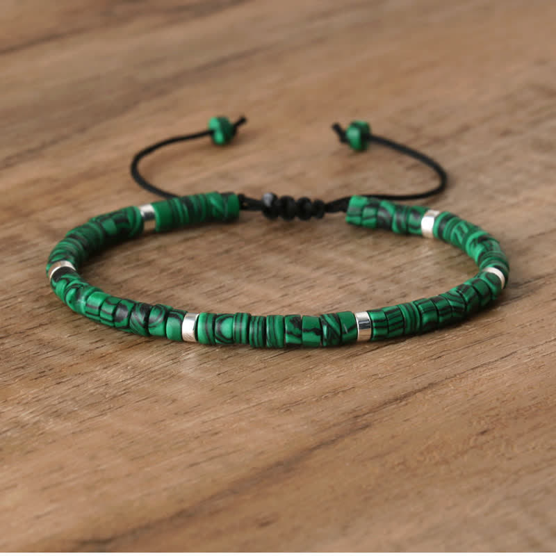 Grünes Perlenarmband aus Malachit mit verstellbarem Verschluss auf Holzoberfläche.