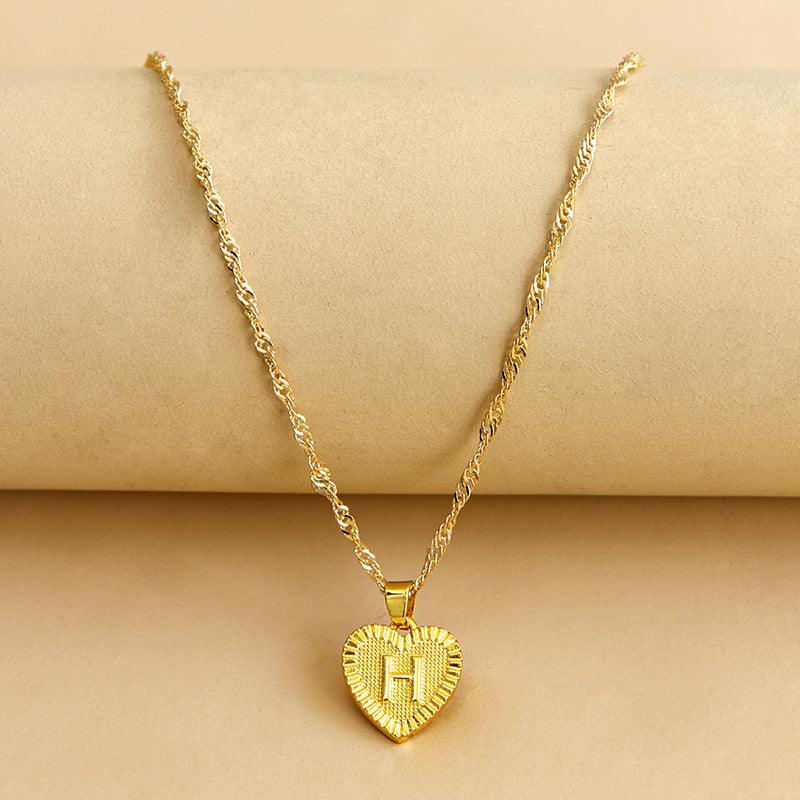 Goldene Herz-Halskette mit Buchstabenanhänger, gedrehtes Kettendesign, eleganter Schmuck.