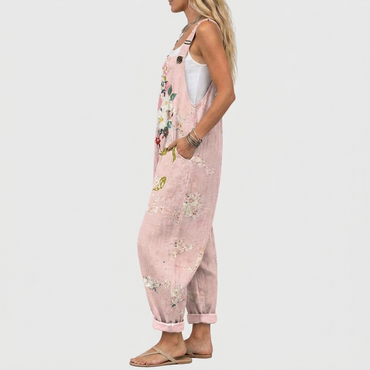 Modellen set fra siden i de lyserøde overalls, der viser den løse pasform, stroppen med knap og sidelommen. 3
