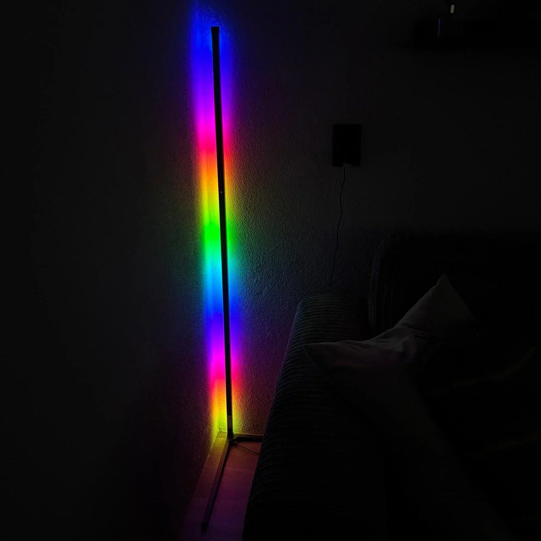 Lampen lyser i flere farver på én gang i et mørkt rum, med sofa og pude ved siden af. 6