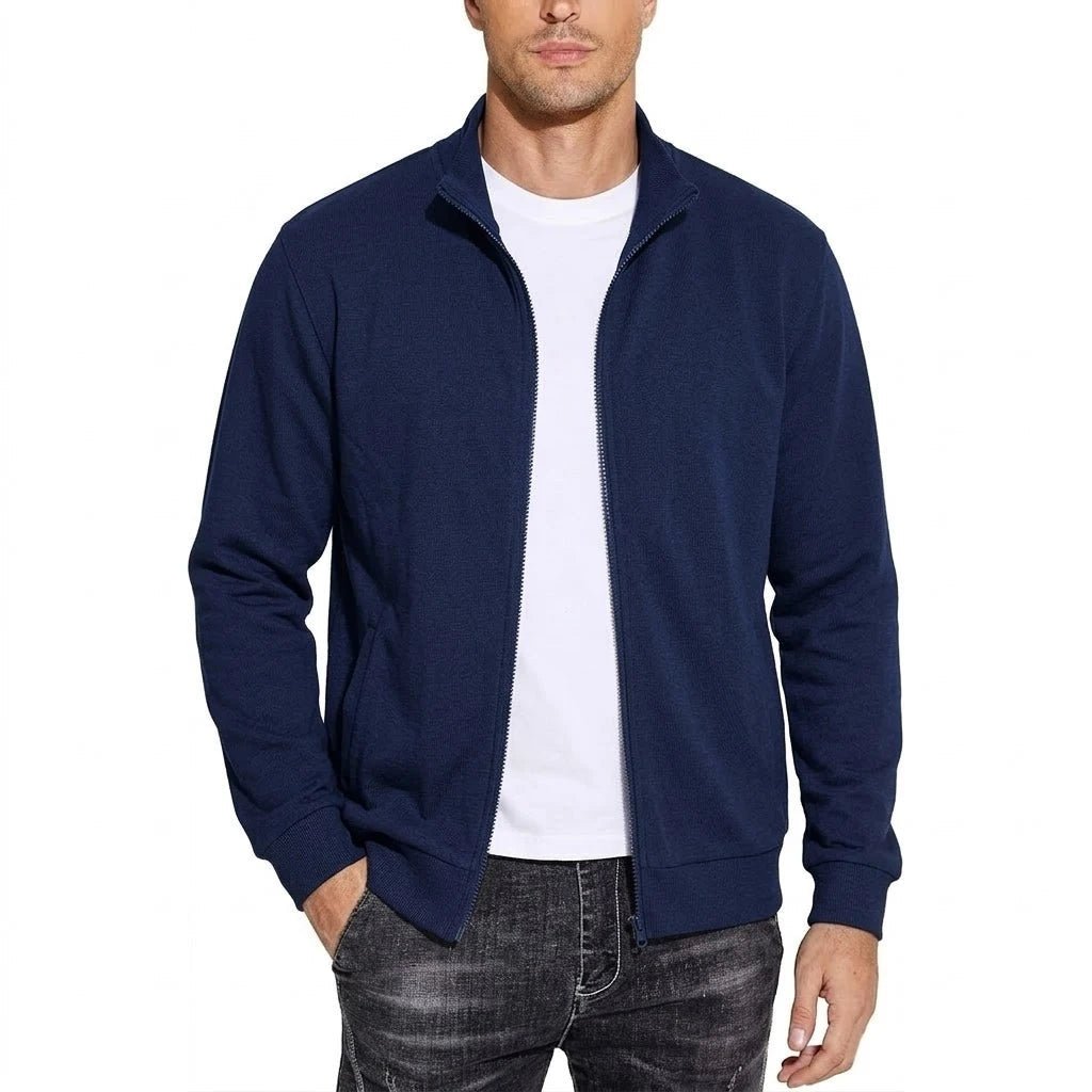 Mand i marineblå sweatshirtjakke med åben lynlås over hvid t-shirt, den ene hånd i lommen, set forfra. 3
