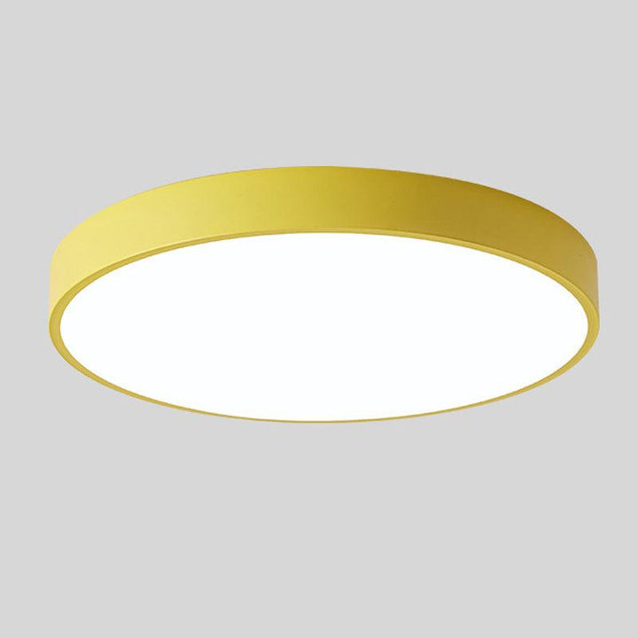 Gul rund loftslampe uden trædetalje fotograferet alene mod lys grå baggrund. 9