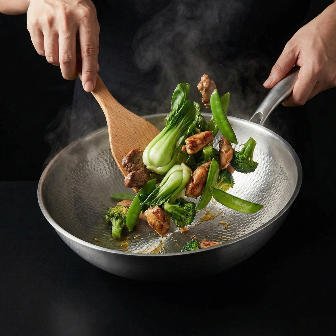 To hænder rører rundt i wokpanden med en træspatel, med kødstykker, pak choi, broccoli og sukkerærter og opstigende damp. 8