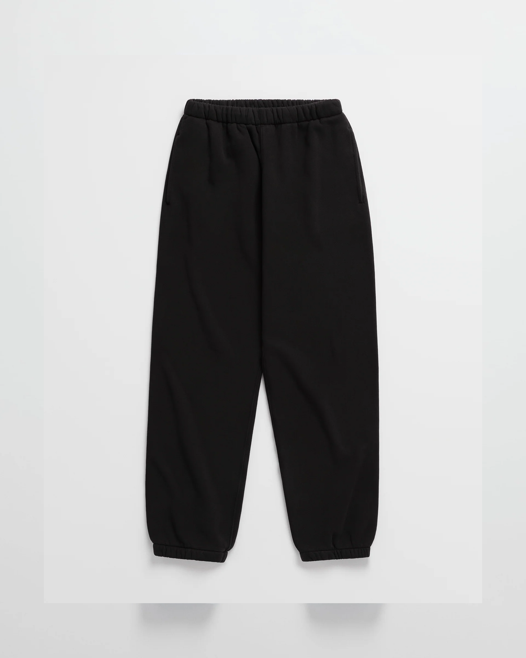 Sorte sweatpants med elastisk talje, sidelommer og elastik forneden på benene, vist fladt forfra. 10