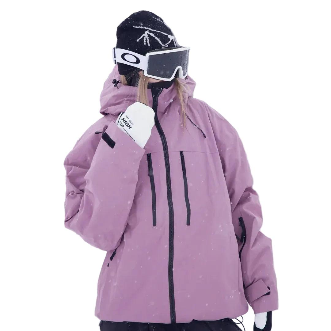 Model i lyselilla snejakke med hætte, skibriller og hvide handsker, hvor den ene hånd er løftet mod hagen. 2