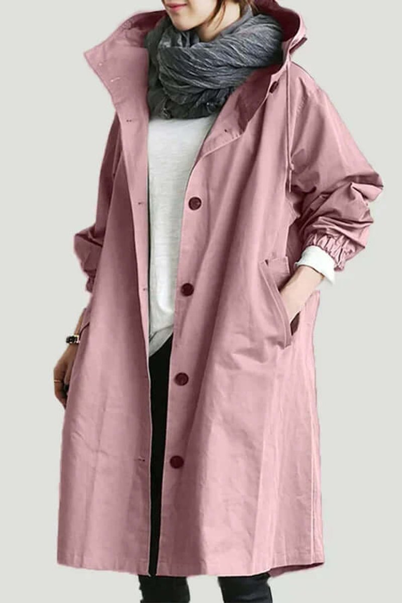 Model i rosa trenchcoat med hætte, knapper og hånd i lommen, båret med tørklæde 1